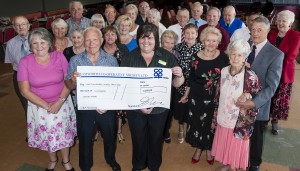 Julie-Ann Kester, manager of the Tamworth Co-op convenience store in Dordon, hands over the cheque to Andy Brown, secretary of North Warwickshire Retired Miners club. Also pictured are some of the club members who will be embarking on a day trip to Llandudno. 