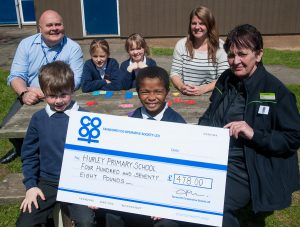 Sheila Villers, manager of Tamworth Co-op Wood End store, presents cheque for £478 to Hurley Primary School after being shown new Numicon maths aid. Head teacher Glyn Morgans is on back row. 