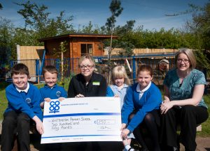Hayley Gilbert, manager of Whittington Co-op, presenting cheque from Community Dividend Fund to Emma Taylor, deputy head of Whittington Primary School, and some pupils. 