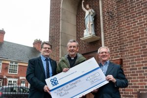 Tamworth Co-op executives hand over cheque for homeless shelter to priest